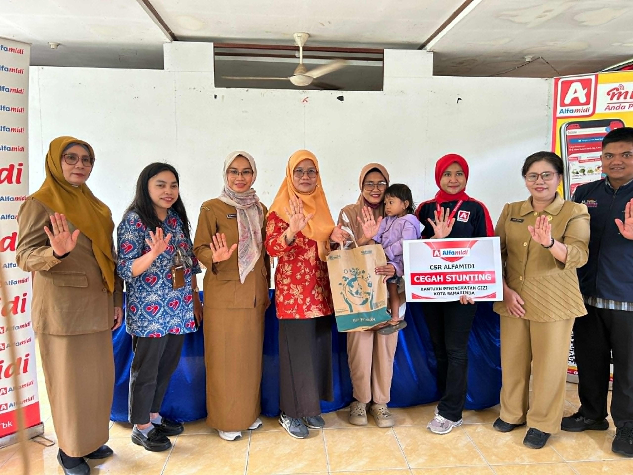 Perwakilan Pemkot Samarinda, Alfamidi Samarinda, dan warga berfoto bersama saat penyaluran program CSR Alfamidi dalam mengentaskan stunting, Selasa (12/11/2024).